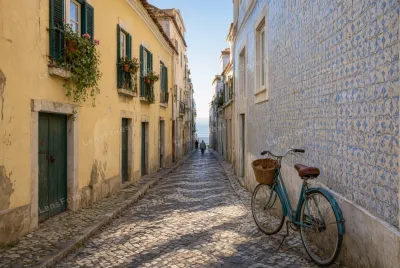 A narrow cobblestone alley in Lisbon with a blue bicycle parked against a wall of blue and white ceramic tiles.
