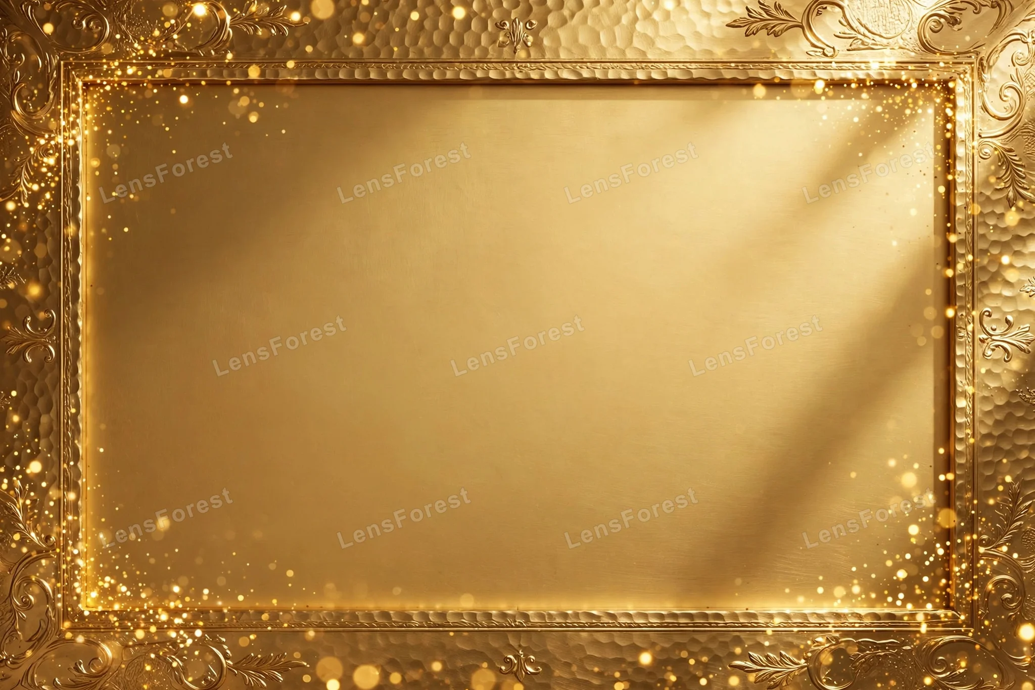 Hammered brushed gold metal background with ornate embossed frame, golden bokeh sparkles and empty copy space in the center